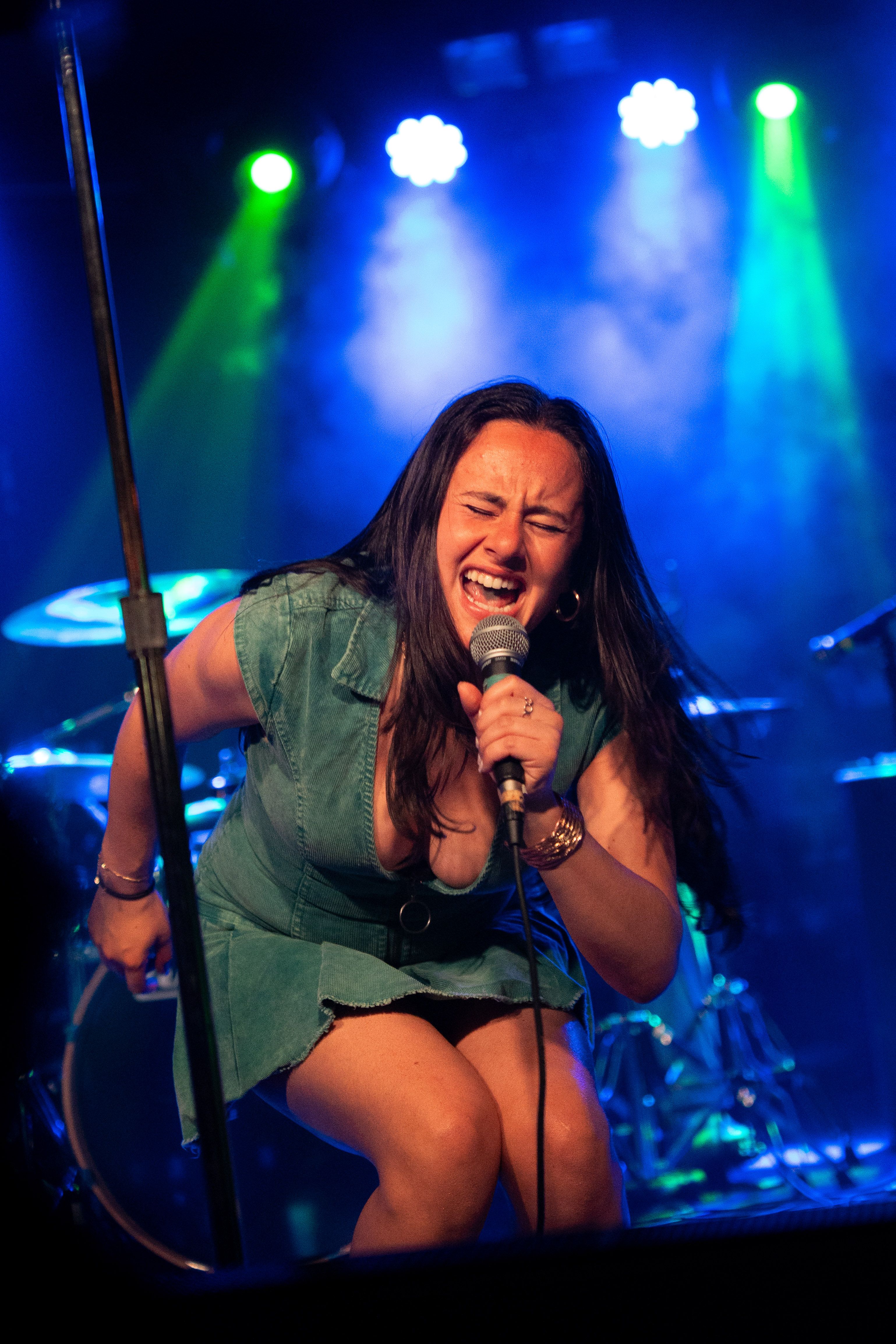 Singer leaning forward in a denim outfit.