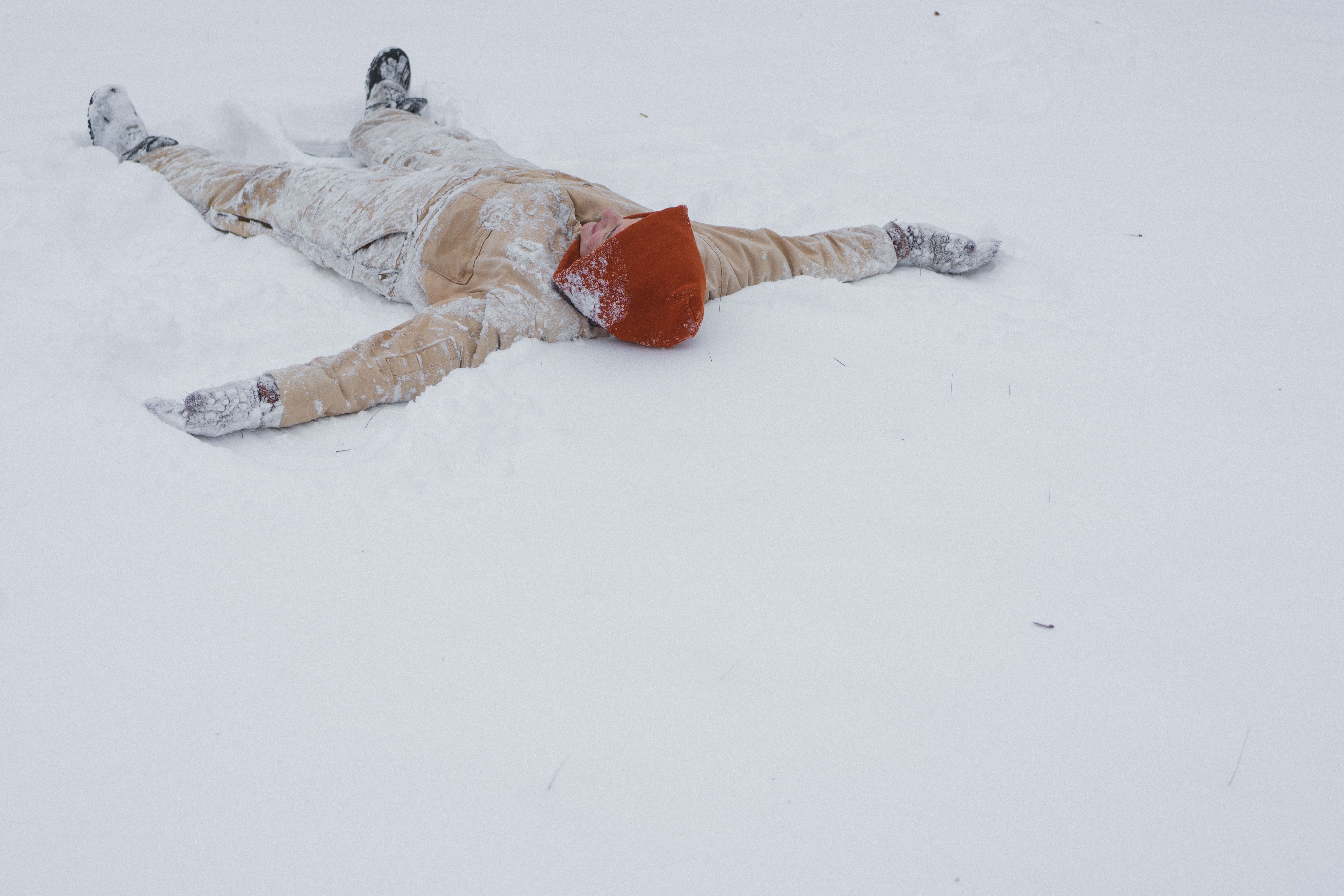 A person lying on snow-covered ground.